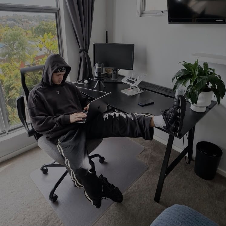 Samuel working at his desk in a hoodie