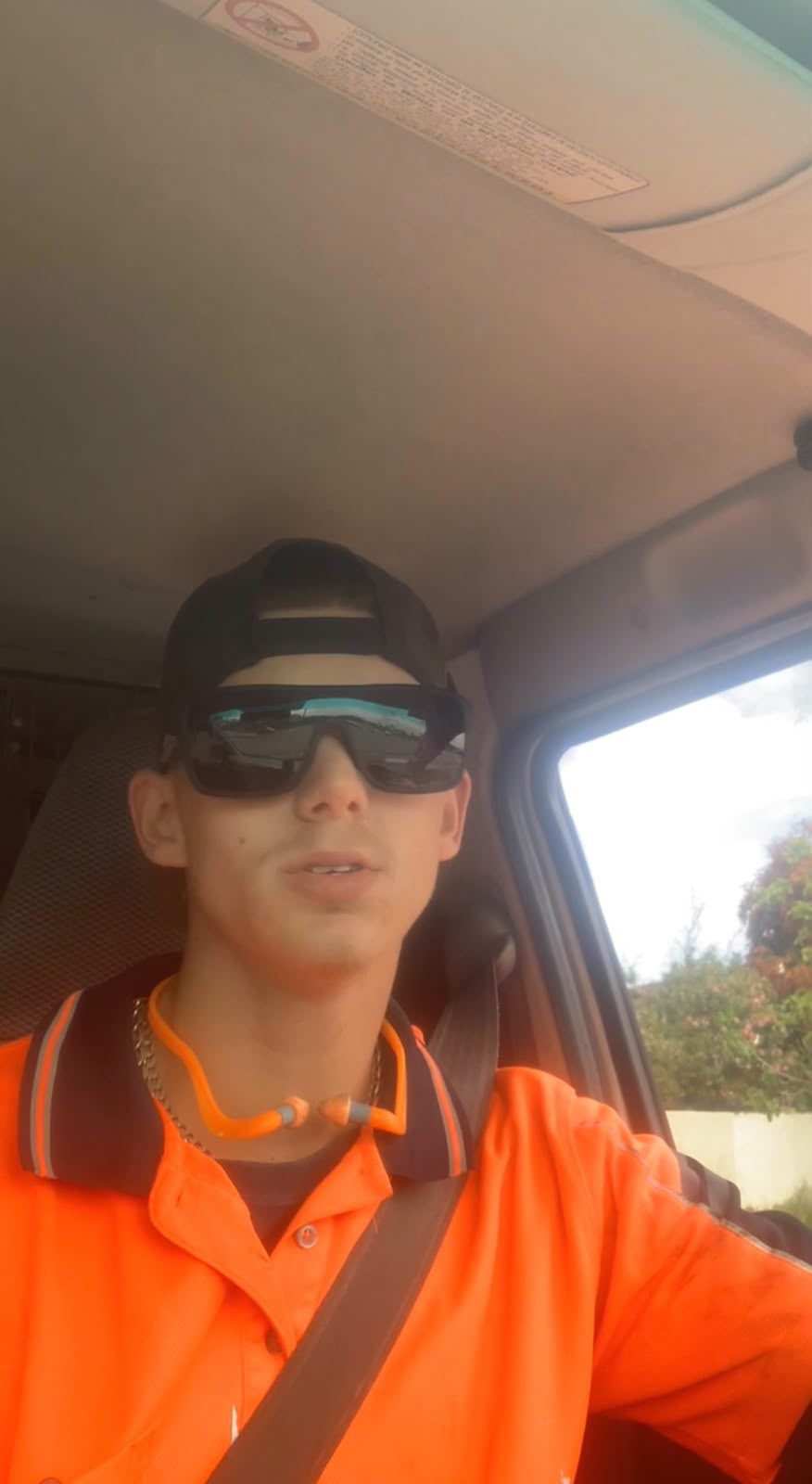 Samuel in hi-vis in the cab of a work ute, before